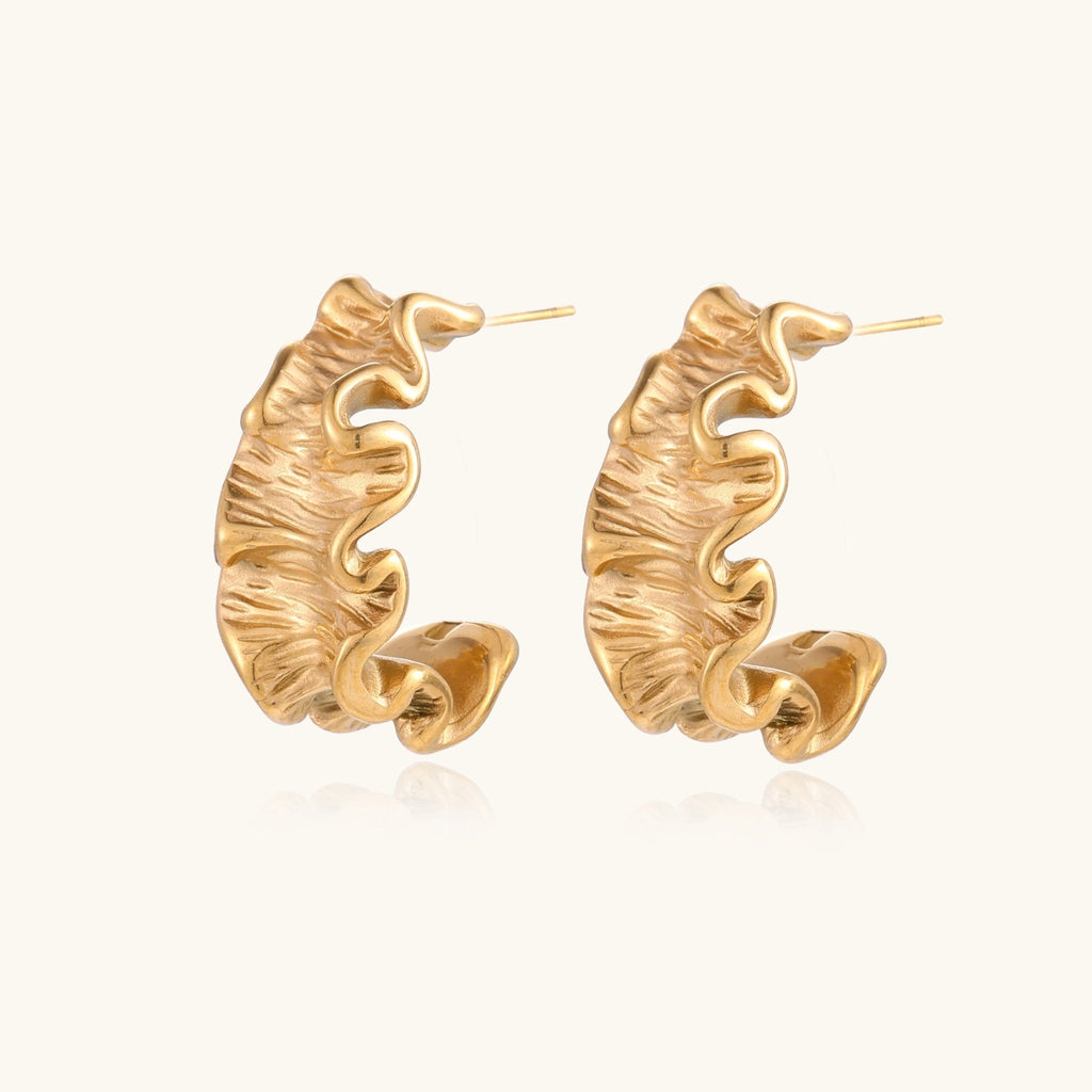 Sculptural gold hoops with textured wave patterns and rippled surface in 14K plating, shown from front and back angles